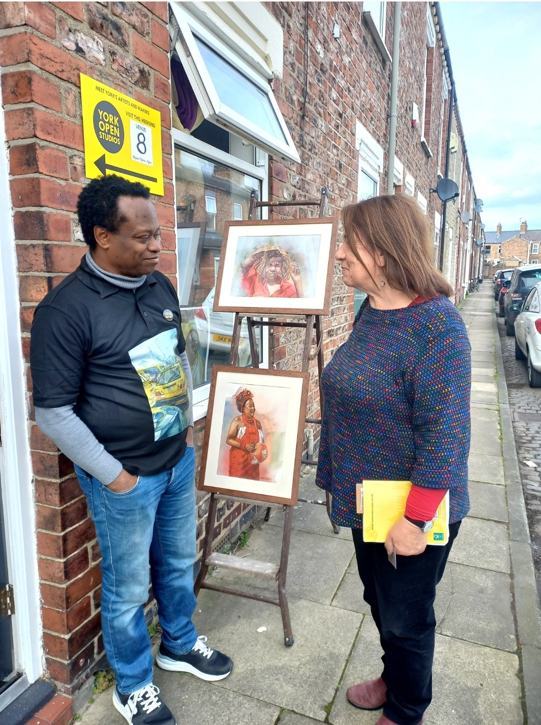 Nduka Omeife sharing his paintings with a studio visitor